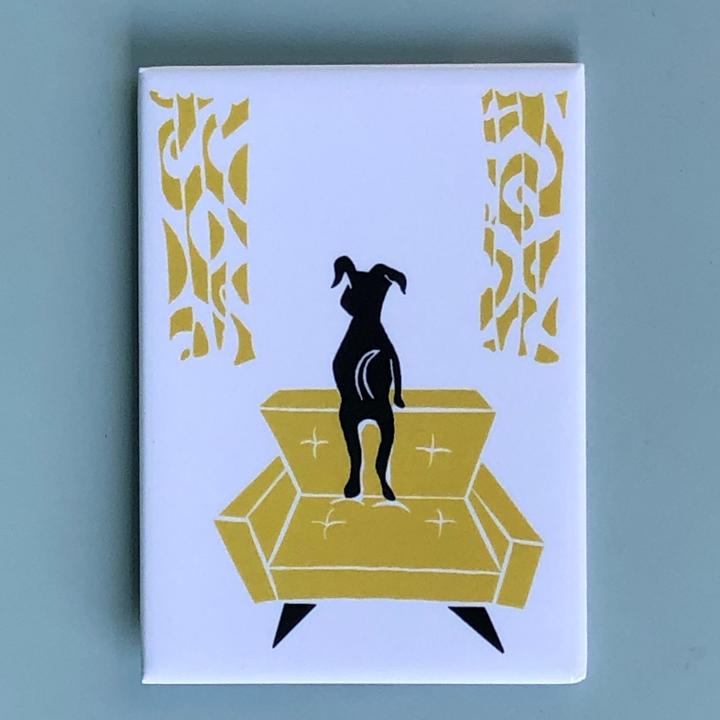 Stylized black dog looking out a window, standing on a yellow midcentury modern chair w/ matching curtains on a white background.