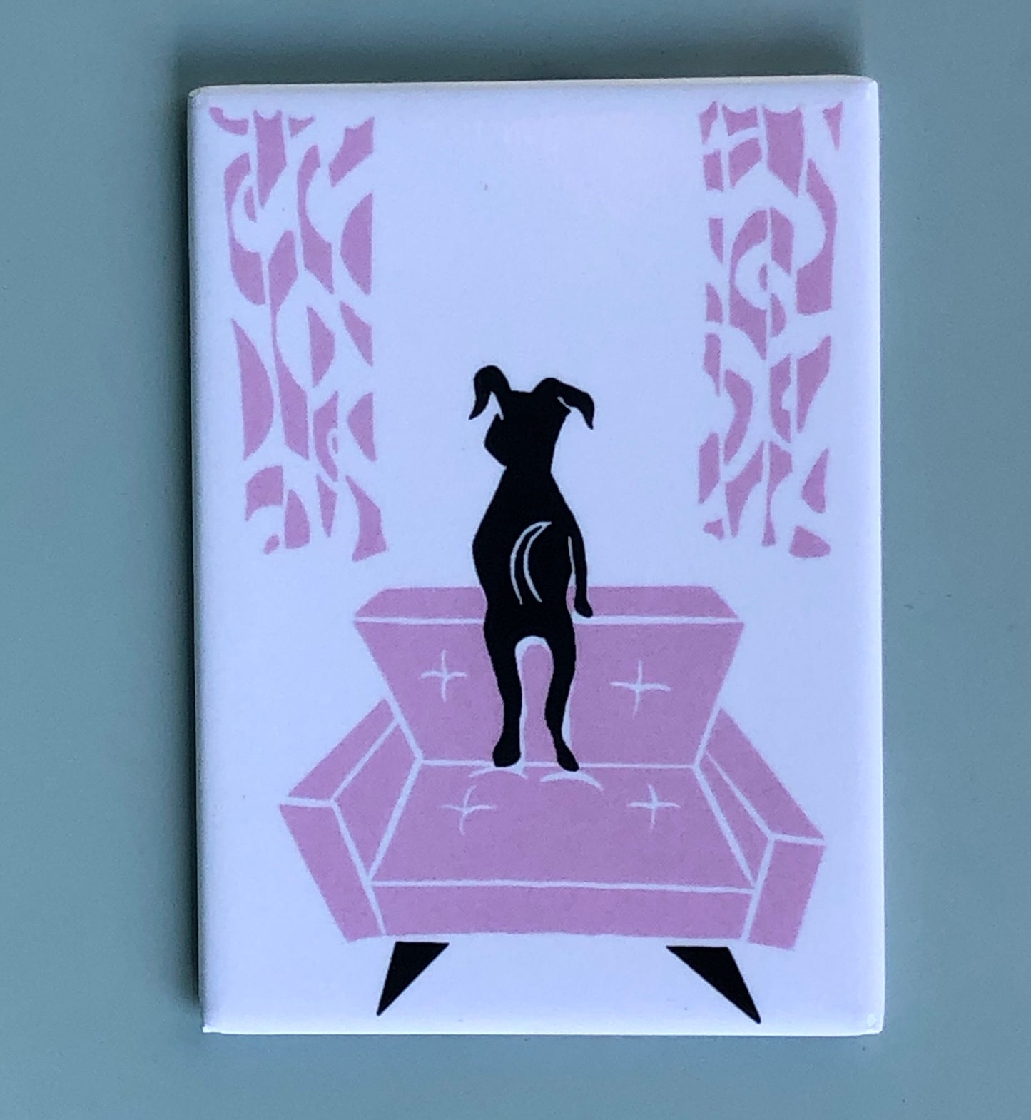 Stylized black dog looking out a window, standing on pink midcentury modern chair w/ matching curtains on a white background.