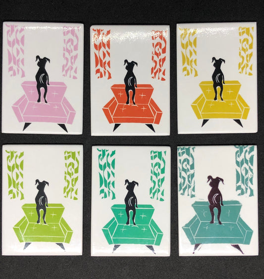 Stylized og looking out a window, standing on midcentury modern chair w/ matching curtains on a white background. Chair colors  top left to right: pink, red-orange, yellow,. Bottom row left to right, green apple, turquoise, aqua.